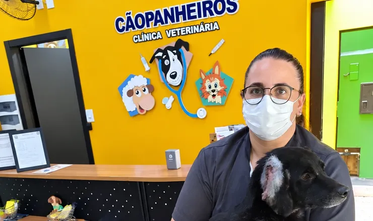 Veterinária da Cãopanheiros com um cão no colo na recepção da clínica